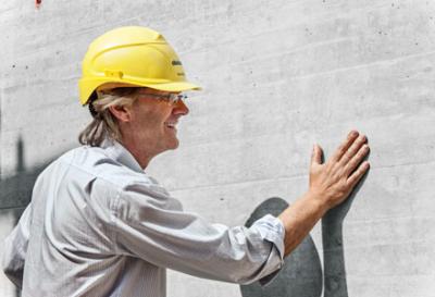 Mann mit Helm vor Sichtbeton